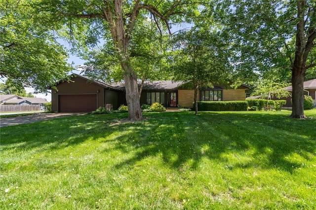 view of front facade featuring an attached garage, a front yard, and driveway