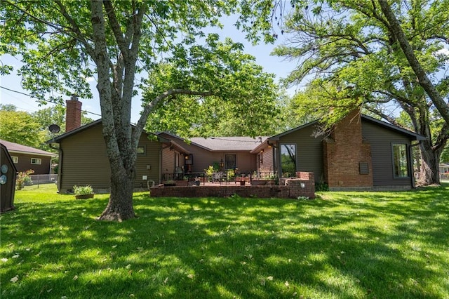 back of house with a lawn and a chimney