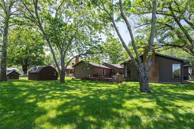 view of green lawn with a storage unit and an outdoor structure
