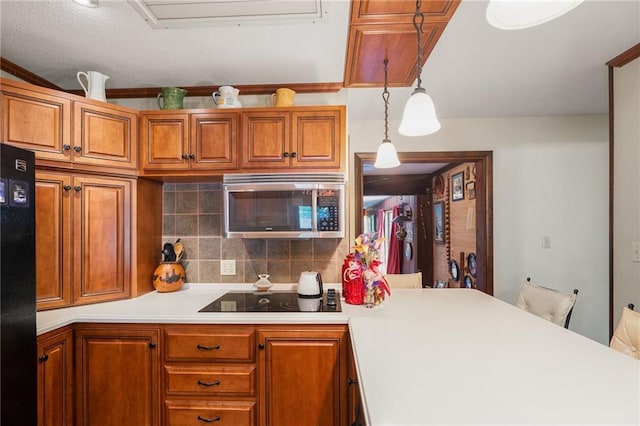 kitchen featuring black appliances, light countertops, brown cabinetry, and tasteful backsplash