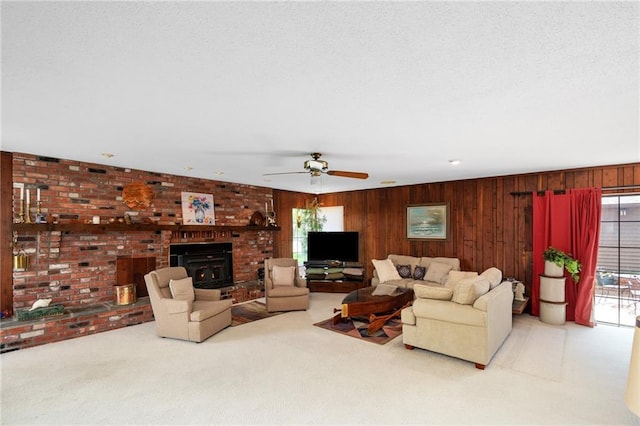 carpeted living room with wood walls, a ceiling fan, and a fireplace