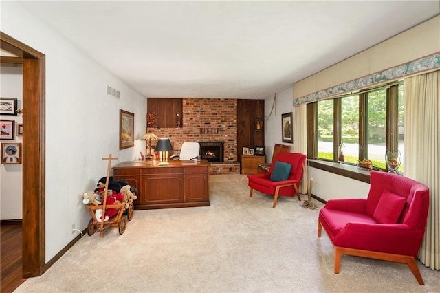 carpeted home office with a brick fireplace and baseboards