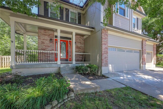 1906 Blackbird Cir, Kearney, MO 64060 - view of front of house with brick siding, covered porch, an attached garage, and concrete driveway