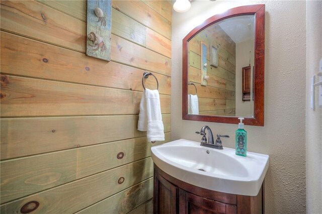 1906 Blackbird Cir, Kearney, MO 64060 - bathroom with vanity, a textured wall, and wooden walls