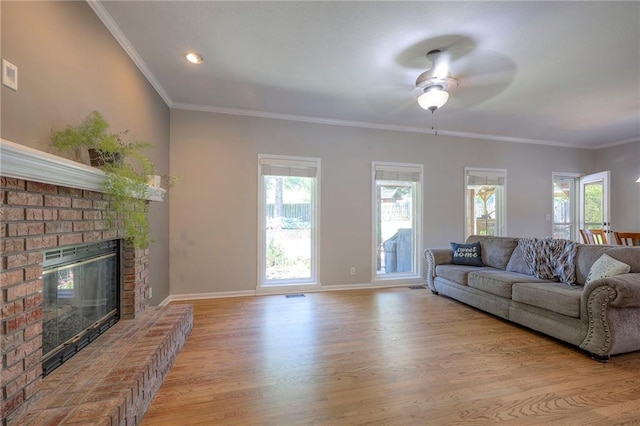 1906 Blackbird Cir, Kearney, MO 64060 - living area featuring light wood-style floors, a ceiling fan, a fireplace, healthy amount of natural light, and ornamental molding