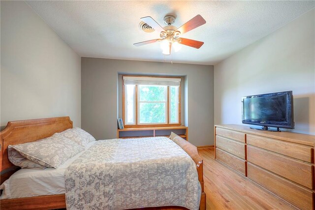 1906 Blackbird Cir, Kearney, MO 64060 - bedroom with light wood-type flooring, a ceiling fan, and a textured ceiling