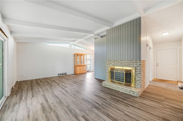unfurnished living room featuring wood finished floors and a brick fireplace