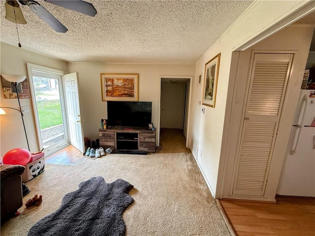 2317 Englewood Ct, Independence, MO 64052 - living room featuring a textured ceiling, a ceiling fan, and wood finished floors