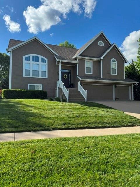 bi-level home featuring an attached garage, a front yard, and concrete driveway