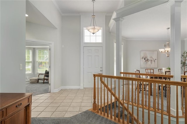 14393 S Cody St, Olathe, KS 66062 - entrance foyer featuring light colored carpet, ornate columns, crown molding, light tile patterned floors, and a chandelier