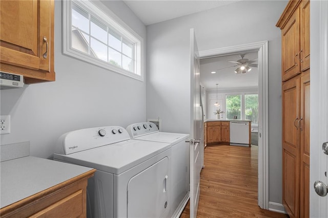 14393 S Cody St, Olathe, KS 66062 - laundry area featuring cabinet space, washer and dryer, a ceiling fan, and wood finished floors