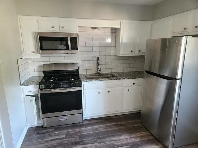 6126 Farrow Ave, Kansas City, KS 66104 - kitchen featuring appliances with stainless steel finishes, a sink, tasteful backsplash, and white cabinetry