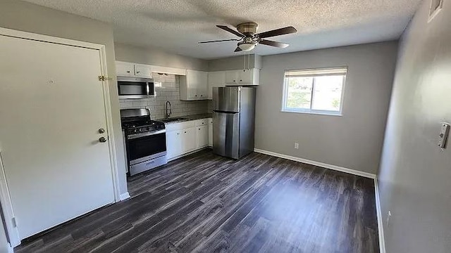 6126 Farrow Ave, Kansas City, KS 66104 - kitchen with appliances with stainless steel finishes, a sink, backsplash, white cabinets, and ceiling fan