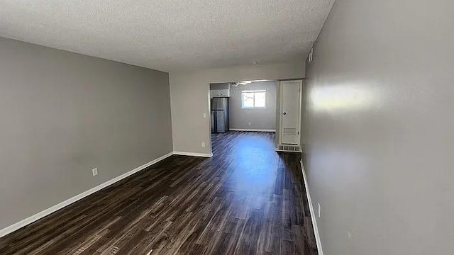 6126 Farrow Ave, Kansas City, KS 66104 - corridor with dark wood-style flooring, a textured ceiling, and baseboards