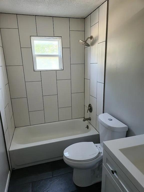 6126 Farrow Ave, Kansas City, KS 66104 - bathroom with toilet, a textured ceiling, shower / bath combination, vanity, and tile patterned flooring