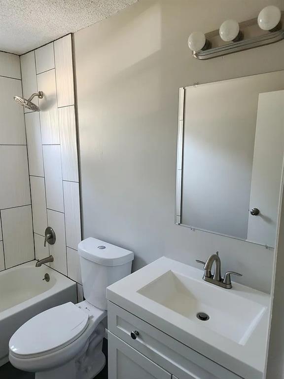 6126 Farrow Ave, Kansas City, KS 66104 - full bath with toilet, a textured ceiling, vanity, and shower / bathtub combination