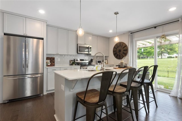 1405 Newport Ln, Raymore, MO 64083 - kitchen featuring stainless steel appliances, a sink, light countertops, backsplash, and dark wood-type flooring