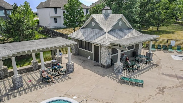 16049 S Brookfield St, Olathe, KS 66062 - rear view of house featuring stone siding, a patio, a pergola, stucco siding, and an outbuilding
