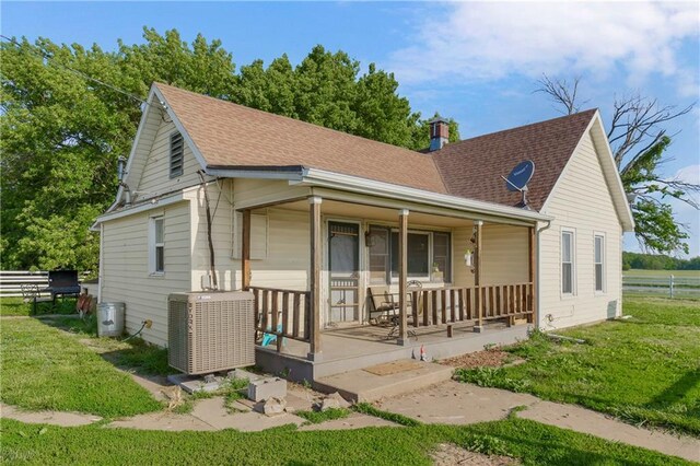 1332 Clark Rd, Williamsburg, KS 66095 - bungalow-style house featuring covered porch, central AC unit, a chimney, and roof with shingles
