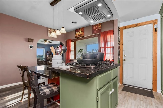 1332 Clark Rd, Williamsburg, KS 66095 - kitchen with green cabinetry, gas cooktop, extractor fan, dark countertops, and light wood-type flooring
