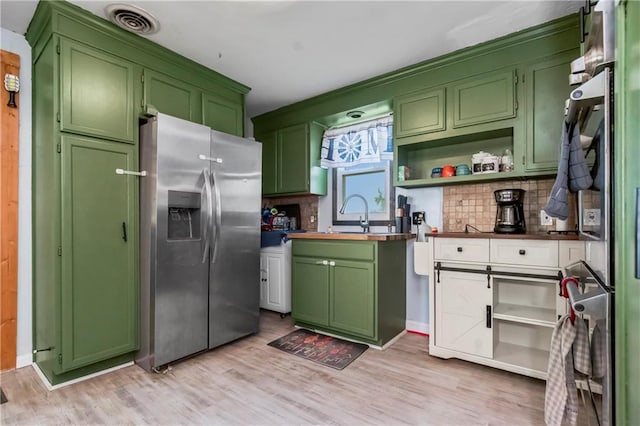 1332 Clark Rd, Williamsburg, KS 66095 - kitchen with stainless steel fridge with ice dispenser, green cabinetry, backsplash, and light wood-style floors