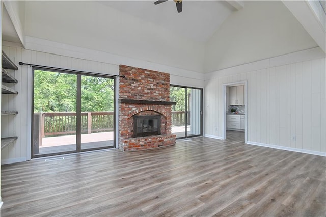 3512 Apple Tree Ln, Gladstone, MO 64119 - unfurnished living room with high vaulted ceiling, a ceiling fan, wood finished floors, a fireplace, and beamed ceiling