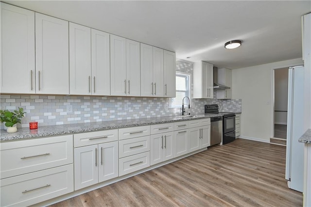 3512 Apple Tree Ln, Gladstone, MO 64119 - kitchen with black electric range oven, white cabinets, light wood-type flooring, and backsplash