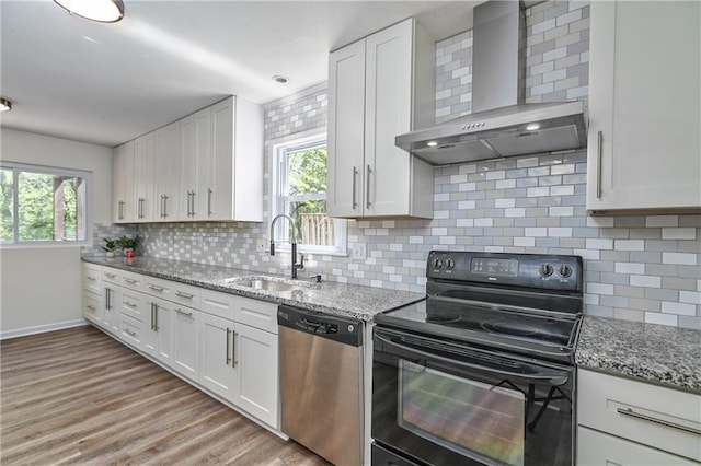 3512 Apple Tree Ln, Gladstone, MO 64119 - kitchen with stainless steel dishwasher, wall chimney range hood, black / electric stove, a sink, and white cabinetry