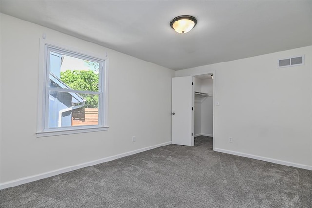 3512 Apple Tree Ln, Gladstone, MO 64119 - unfurnished bedroom with dark carpet, baseboards, and a walk in closet