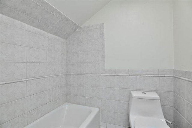 3512 Apple Tree Ln, Gladstone, MO 64119 - bathroom with vaulted ceiling, a bathtub, tile walls, and toilet