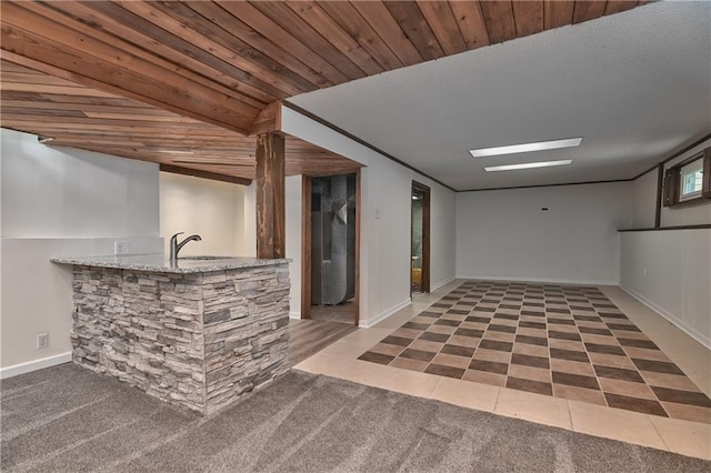 3512 Apple Tree Ln, Gladstone, MO 64119 - finished basement with bar with sink, tile patterned floors, carpet, and baseboards