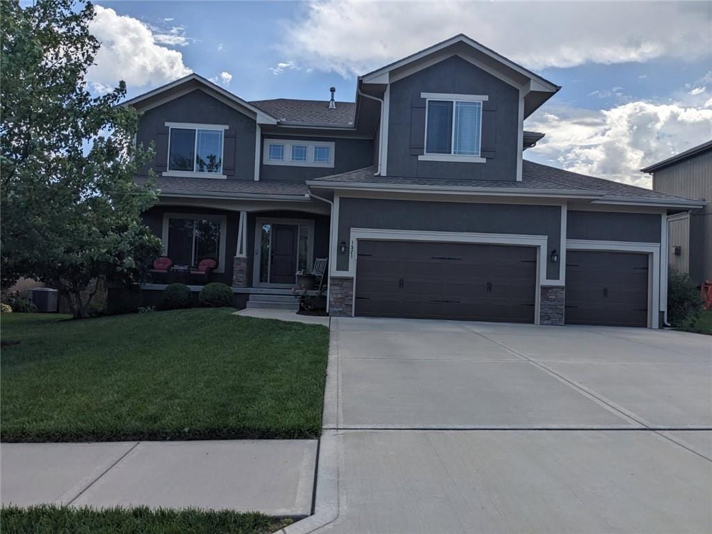 1521 SW Whistle Dr, Lees Summit, MO 64082 - view of front facade featuring a front yard, stucco siding, and stone siding