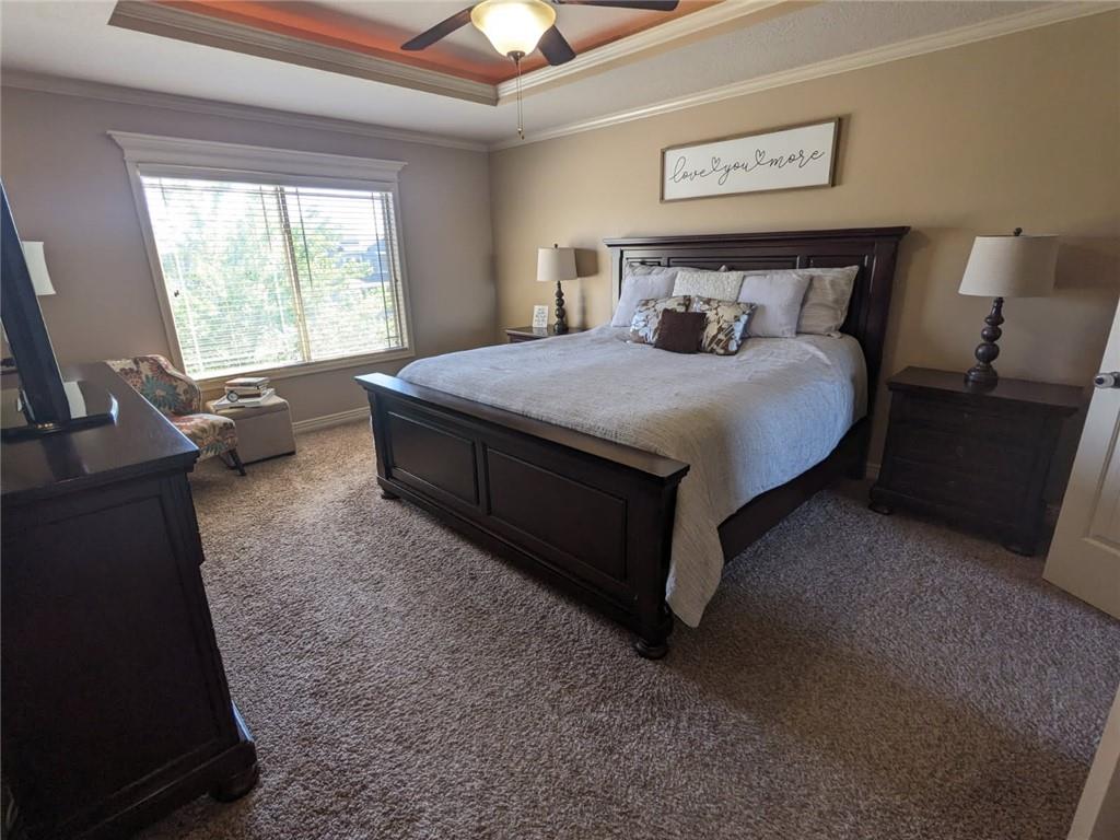 1521 SW Whistle Dr, Lees Summit, MO 64082 - bedroom featuring a raised ceiling, light carpet, crown molding, a ceiling fan, and baseboards