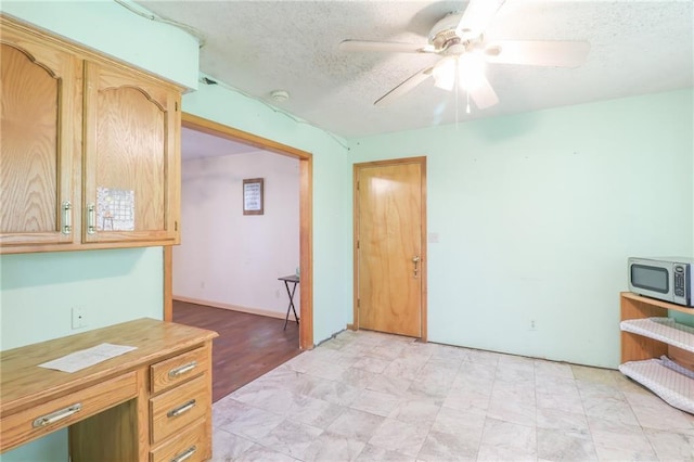 1175 SW State Route 58th Hwy, Holden, MO 64040 - kitchen with stainless steel microwave, a textured ceiling, ceiling fan, light countertops, and light brown cabinets