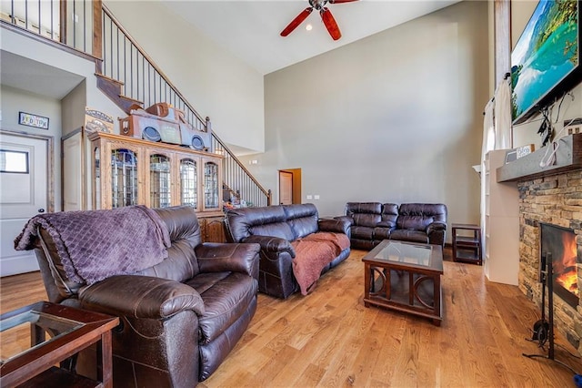 4000 S Buckner Tarsney Rd, Grain Valley, MO 64029 - living room with a high ceiling, stairs, a ceiling fan, a fireplace, and wood finished floors