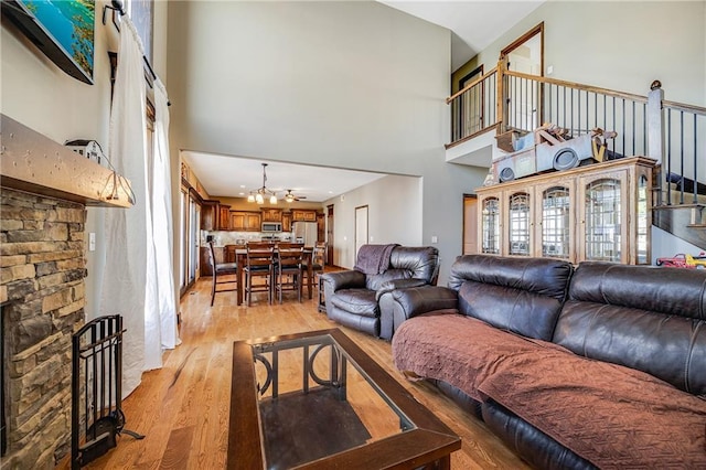 4000 S Buckner Tarsney Rd, Grain Valley, MO 64029 - living area with light wood-type flooring, a towering ceiling, a chandelier, and healthy amount of natural light
