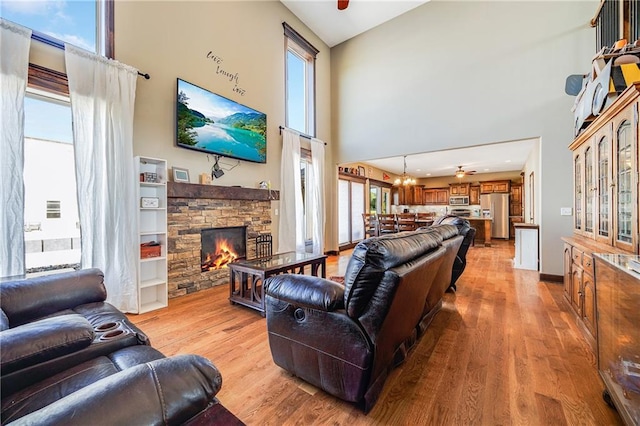 4000 S Buckner Tarsney Rd, Grain Valley, MO 64029 - living room with a high ceiling, healthy amount of natural light, light wood-style floors, and a stone fireplace