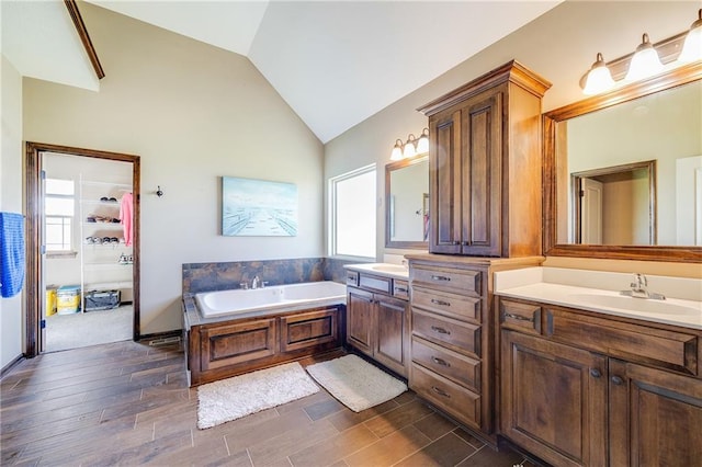 4000 S Buckner Tarsney Rd, Grain Valley, MO 64029 - bathroom with double vanity, vaulted ceiling, wood finished floors, and a garden tub