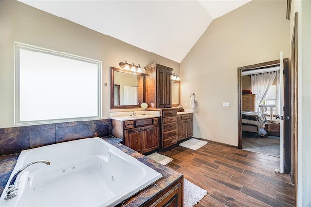 4000 S Buckner Tarsney Rd, Grain Valley, MO 64029 - bathroom with connected bathroom, vanity, a tub with jets, wood finished floors, and high vaulted ceiling