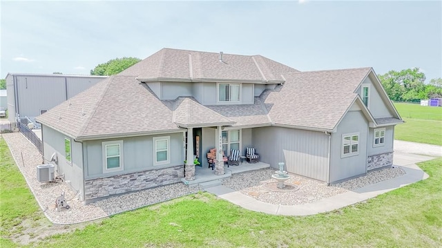4000 S Buckner Tarsney Rd, Grain Valley, MO 64029 - view of front of home featuring a front yard, a patio, roof with shingles, and stone siding