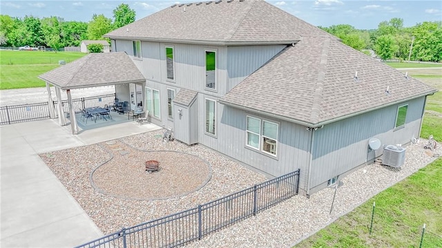 4000 S Buckner Tarsney Rd, Grain Valley, MO 64029 - rear view of property with a shingled roof, central air condition unit, a patio area, a gazebo, and a fire pit