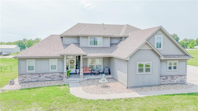 4000 S Buckner Tarsney Rd, Grain Valley, MO 64029 - view of front of house featuring stone siding, a patio area, a front yard, and roof with shingles