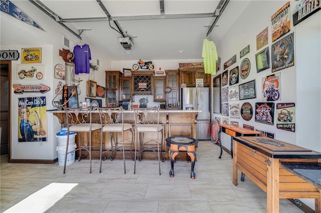 4000 S Buckner Tarsney Rd, Grain Valley, MO 64029 - kitchen featuring stainless steel fridge with ice dispenser, a peninsula, a kitchen bar, glass insert cabinets, and light countertops