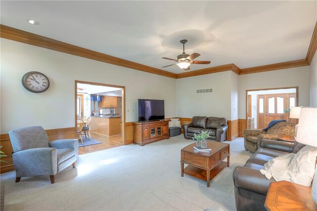 1407 SW Meyer Blvd, Blue Springs, MO 64015 - living room with crown molding, ceiling fan, wainscoting, and light carpet