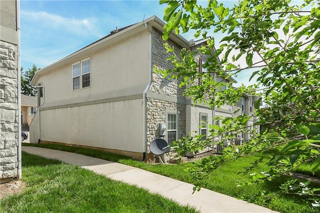 1201 N Mart-Way Dr Unit 109, Olathe, KS 66061 - view of side of home with stone siding, stucco siding, and a lawn