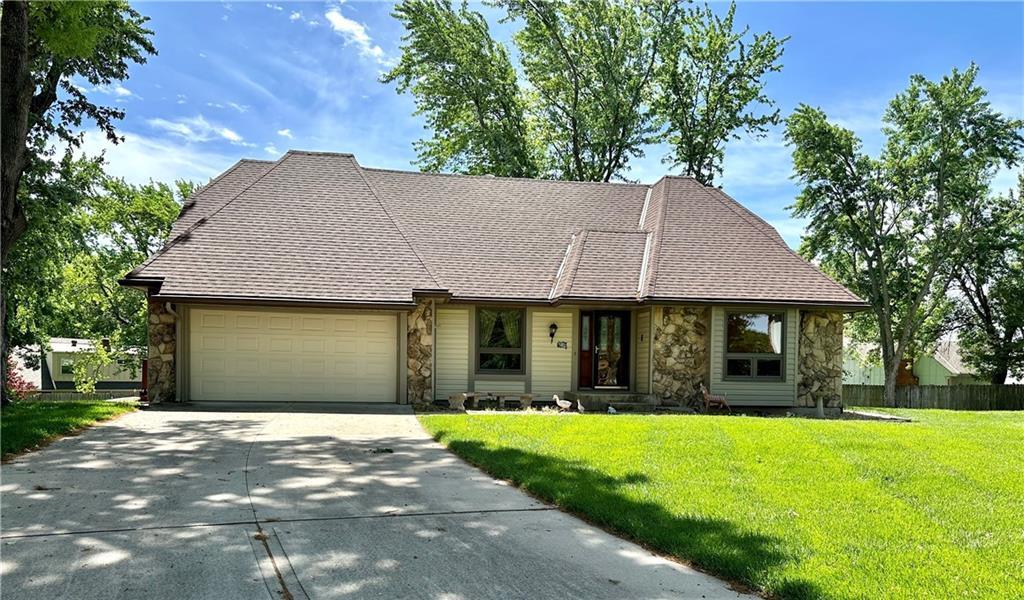 10951 Nieman Rd, Overland Park, KS 66210 - view of front facade with stone siding, a garage, and concrete driveway