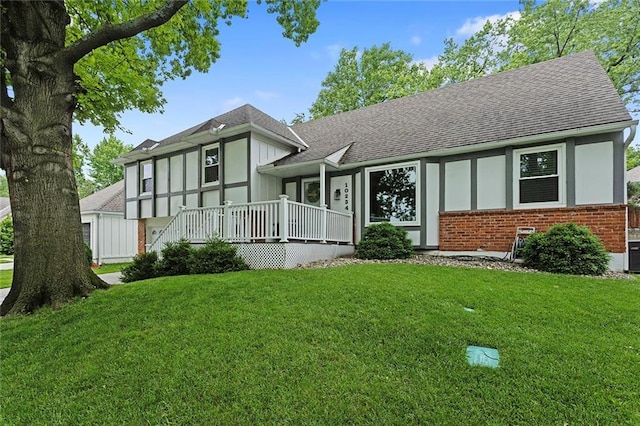 10234 Monrovia St, Lenexa, KS 66215 - tudor home featuring a shingled roof, brick siding, and a front lawn