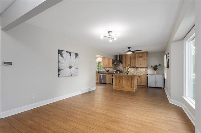 10234 Monrovia St, Lenexa, KS 66215 - kitchen with appliances with stainless steel finishes, wall chimney range hood, wood finished floors, and a center island