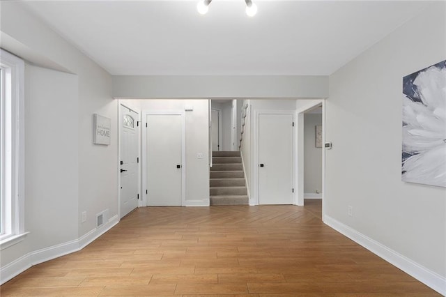 10234 Monrovia St, Lenexa, KS 66215 - spare room with stairs, light wood finished floors, and baseboards