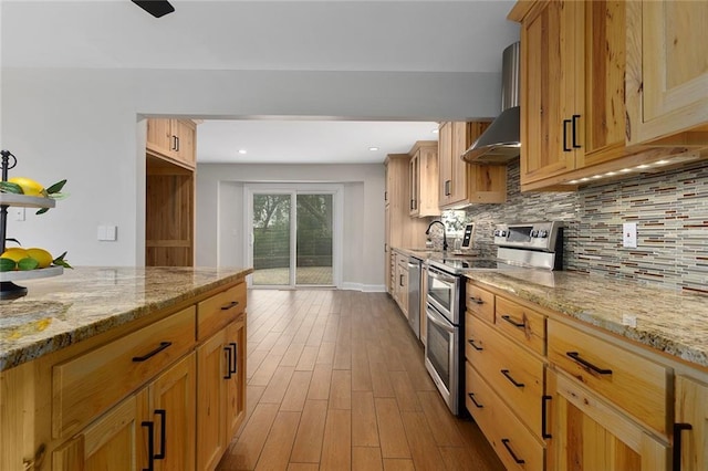 10234 Monrovia St, Lenexa, KS 66215 - kitchen with appliances with stainless steel finishes, wall chimney range hood, wood finished floors, decorative backsplash, and light stone countertops